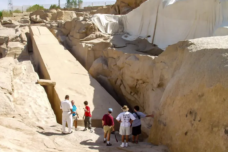 Visitors beside the Unfinished Obelisk in its granite quarry