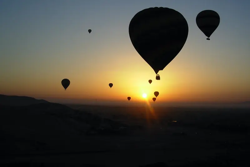 Balloons silhouetted against the sunrise