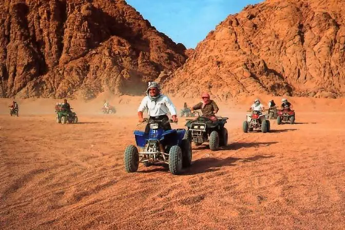 Riding quad bikes between desert mountains